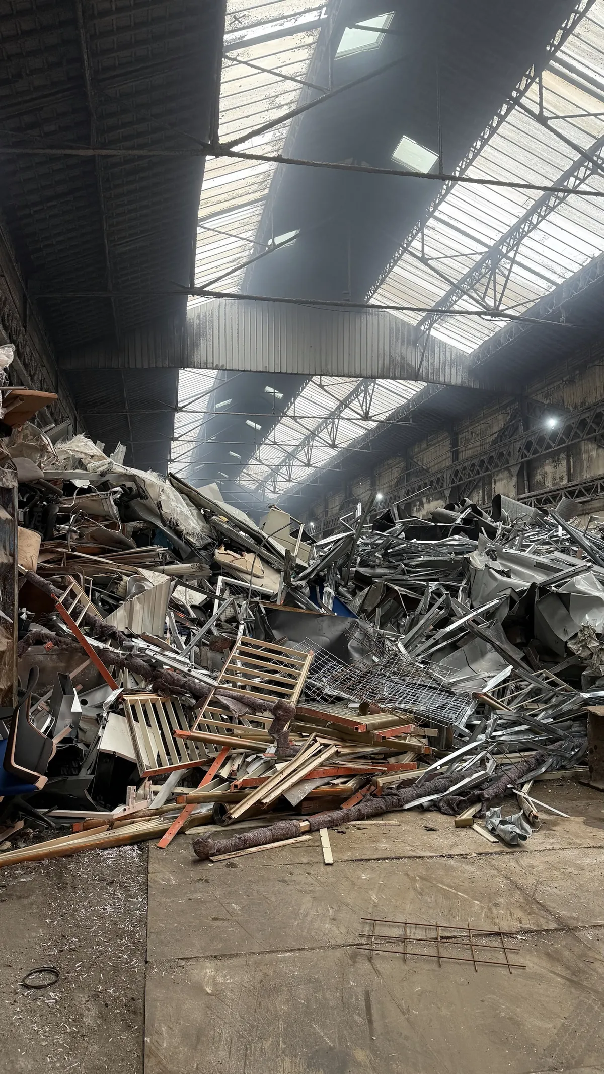 Dans la halle de Safars Métaux, la pelle trie un tas de ferrailles